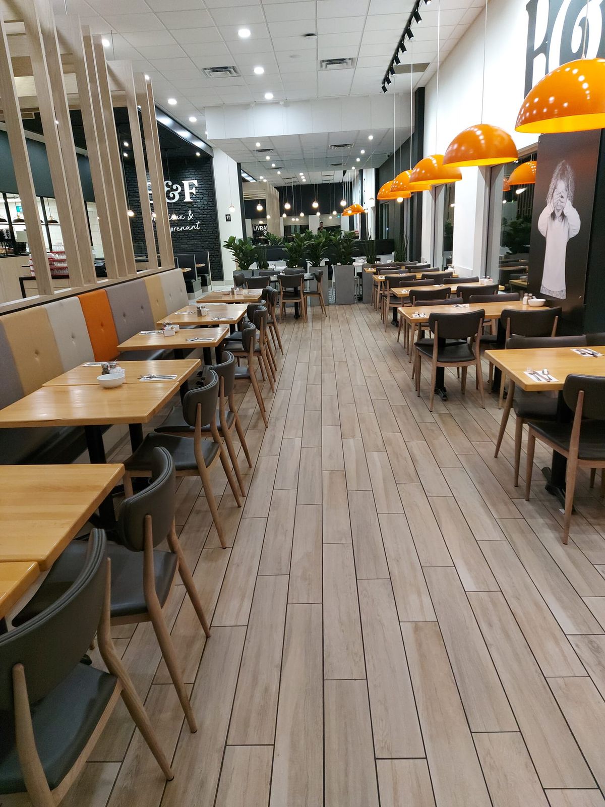 Salle à manger de restaurant vide après la fermeture, tables dressées et plancher de tuile imitation bois